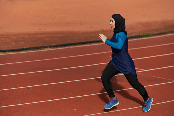 Muslimka v burce sportovní muslimské oblečení běží na maratonském kurzu a připravuje se na nadcházející soutěže.  - Fotografie, Obrázek