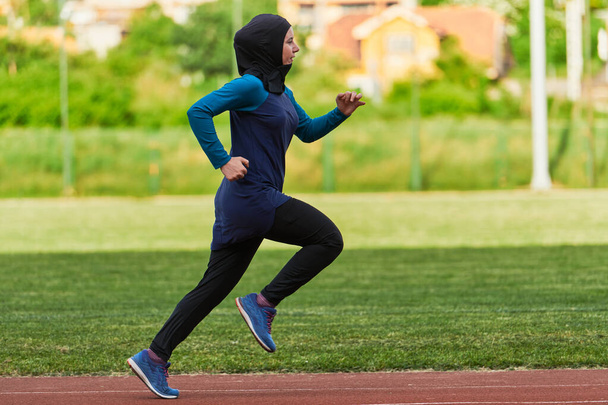 A muslim woman in a burqa sports muslim clothes running on a marathon course and preparing for upcoming competitions.  - Φωτογραφία, εικόνα