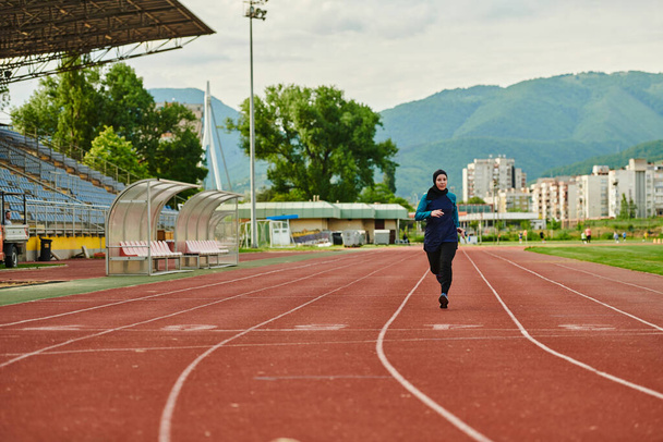 A muslim woman in a burqa sports muslim clothes running on a marathon course and preparing for upcoming competitions.  - Фото, зображення