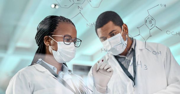 Испытание новой формулы. два учёных рисуют молекулярные структуры на стеклянной стене в лаборатории - Фото, изображение