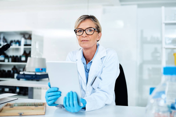 Capturing data with utmost ease. Portrait of a mature scientist using a digital tablet in a lab - Photo, Image