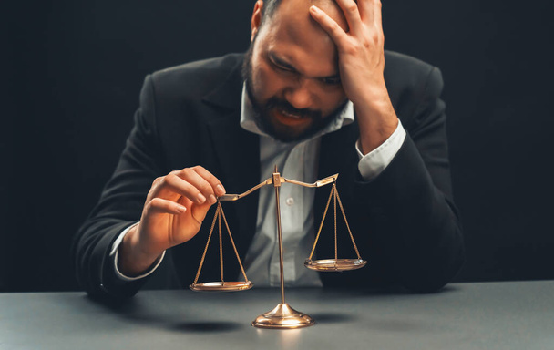Focus mittakaavassa tasapaino hämärä asianajaja istuu pöydällään huolissaan ja uupunut ilme, tunne painon painetta ja stressiä tehdä vaikeita päätöksiä tuomiosta. tasavertaisuus - Valokuva, kuva