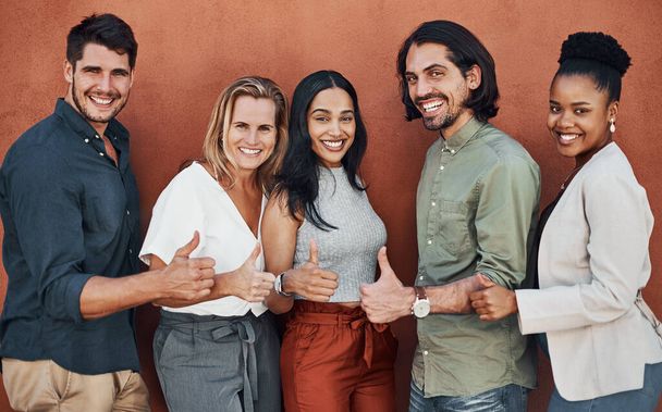 Were destined for success. Cropped portrait of a diverse group of businesspeople standing and making a thumbs up gesture against a wall outside - Φωτογραφία, εικόνα