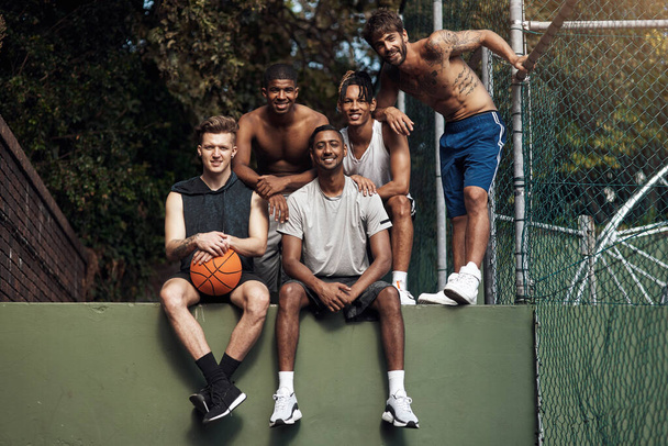 Basketbal celý den, každý den. Portrét skupiny sportovních mladých mužů, kteří se poflakují na basketbalovém hřišti - Fotografie, Obrázek
