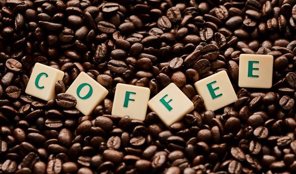 誰かコーヒーとか言った？。コーヒー豆の山の上に単語コーヒーを形成するブロック文字の閉鎖ショット - 写真・画像