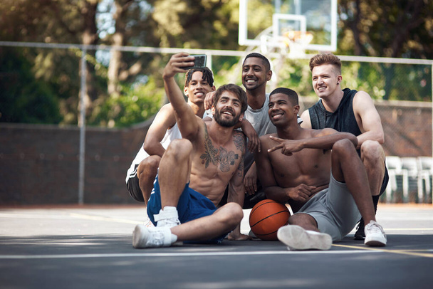 Vain joukko koripalloilijoita. ryhmä urheilullisia nuoria, jotka ottavat selfieitä yhdessä urheilukentällä - Valokuva, kuva