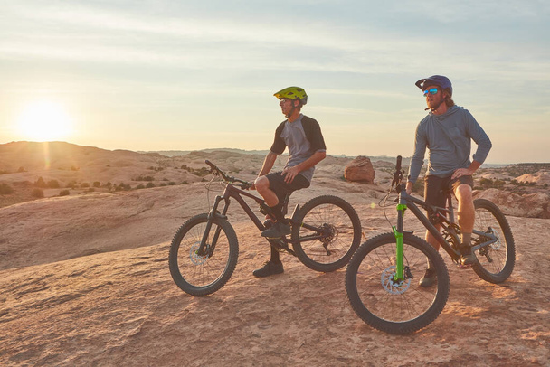 Pronto para aventuras na trilha. Tiro de comprimento total de dois jovens atletas do sexo masculino mountain bike no deserto - Foto, Imagem