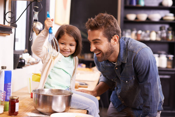 Μαγειρική, πρωινό και ο πατέρας με την κόρη στην κουζίνα για τηγανίτες, συγκόλληση και μάθηση. Φαγητό, πρωινό και βοήθεια με τον άνδρα και τη νεαρή κοπέλα στο οικογενειακό σπίτι για το ψήσιμο, την υποστήριξη και τη διδασκαλία της διατροφής. - Φωτογραφία, εικόνα