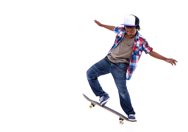 Skateboard, zwarte jongen en kind in een studio met mockup en spring truc met jonge stijl. Geïsoleerde, witte achtergrond en Afrikaans mannelijk kind met een skateboard en skater met energie en vaardigheid. - Foto, afbeelding