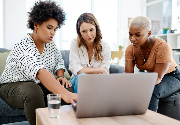 A tirar um momento para rever o seu trabalho. um grupo de mulheres de negócios trabalhando juntas em um laptop em um escritório - Foto, Imagem