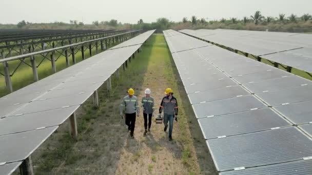Visão superior dos engenheiros inspeciona a construção do painel de células solares. Voo de drone sobrevoar painéis solares campo energia alternativa verde renovável. - Filmagem, Vídeo