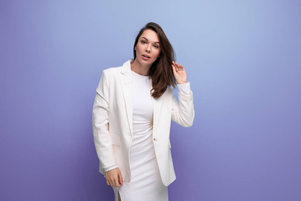 retrato de una joven de negocios de cabello oscuro bien arreglada en un vestido elegante blanco y chaqueta con espacio para copiar. - Foto, Imagen