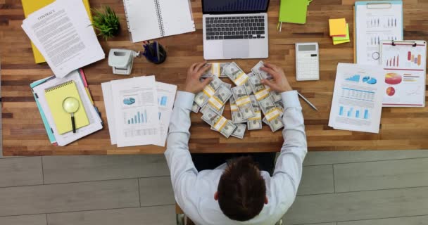 Az üzletember egy rakás pénzt gyűjt össze az asztalnál, az irodai csúcson, a 4k-s filmben. Nyereséges pénzügyi ügyletek az üzleti koncepcióban - Felvétel, videó