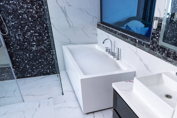 Bath tub with White foam soap bubbles. bath tub in bathroom. Modern ceramic bathtub  - Fotó, kép