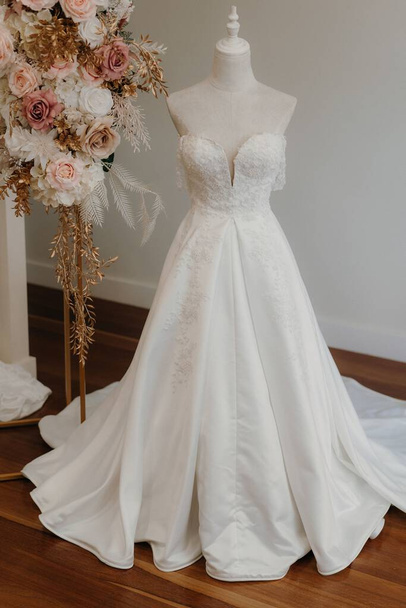 A white elegant wedding dress on a mannequin - Foto, Imagen