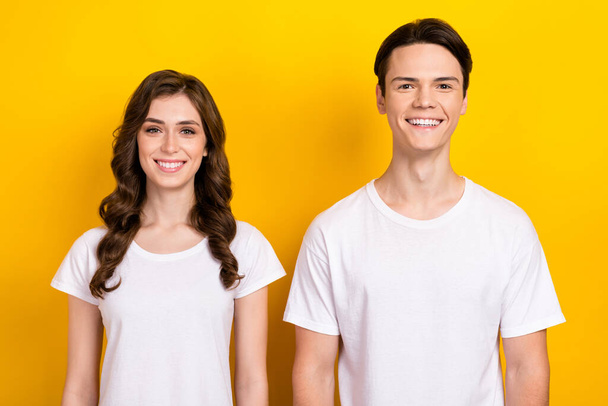 Portrait cadre of young models cheerful couple smiling wear white t-shirt satisfied glad enjoy stylish clothes isolated on yellow color background. - Фото, зображення