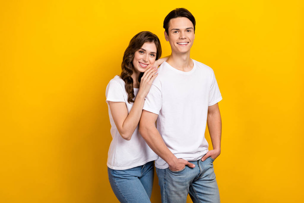 Photo of young lovely people students harmony relationship woman support boyfriend hugs idyllic hands pockets isolated on yellow color background. - Foto, immagini
