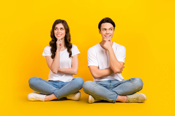 Full length photo of positive dreamy couple wear white t-shirts arms chin looking empty space isolated yellow color background. - Fotografie, Obrázek