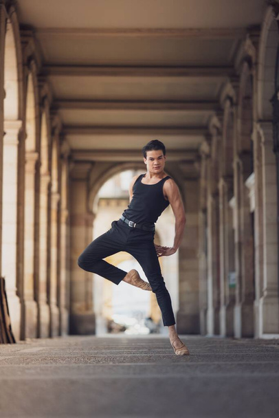 Young man dancing classic ballet in the streets of Barcelona with a beautiful background and light - Foto, Bild