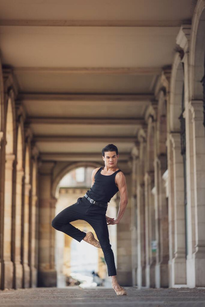 Young man dancing classic ballet in the streets of Barcelona with a beautiful background and light - Foto, Bild