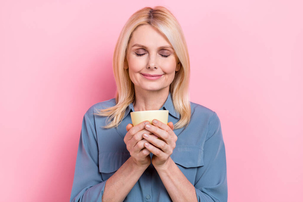 Closeup photo of lady mature age hold coffee cup smell aromatic fresh beverage relax time satisfied closed eyes isolated on pink color background. - Fotografie, Obrázek