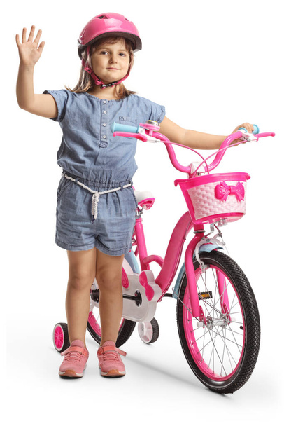 Girl with a helmet standing next to a bicycle and waving isolated on white background - Foto, imagen