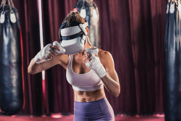Fitness lovers battle against other gym members by wearing virtual reality goggles during intense boxing exercises. Learning and improving boxing techniques, from simple strikes to complex combos - Foto, afbeelding