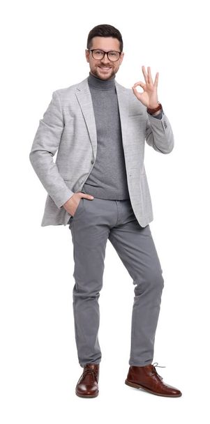 Handsome bearded businessman in eyeglasses showing OK gesture on white background - Foto, Imagen
