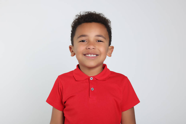 Portrait of cute African-American boy on light grey background - Photo, Image
