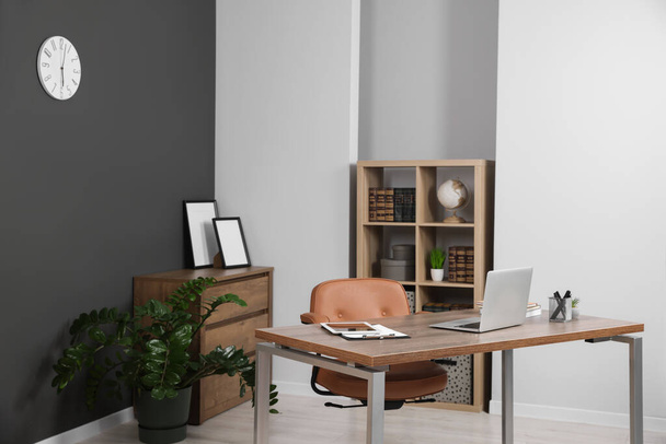Stylish office with modern furniture and laptop on wooden desk. Interior design - Foto, Imagen