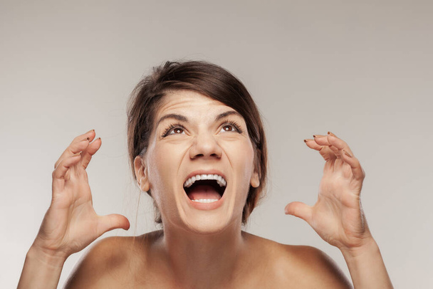 brunette girl screaming and making angry gesture with hands - Foto, Imagen