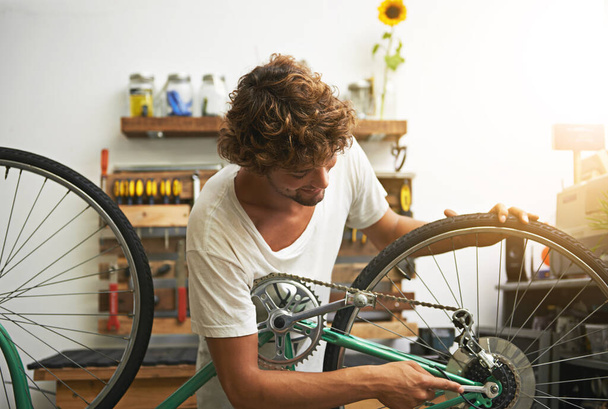 Repair, bicycle and man in a workshop, happy and prepare for training, exercise and competition. Male biker, person and human fixing wheel, cycling and problem solving with maintenance and inspection. - Fotografie, Obrázek