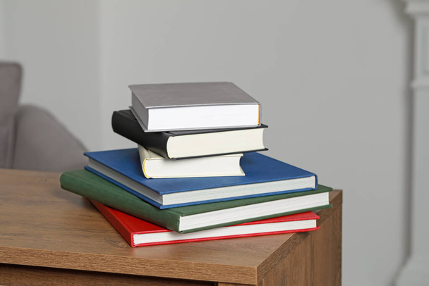 Stack of hardcover books on wooden table indoors - Фото, изображение