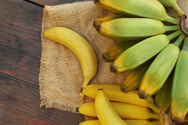 Different sorts of bananas on wooden table, flat lay - Foto, Bild