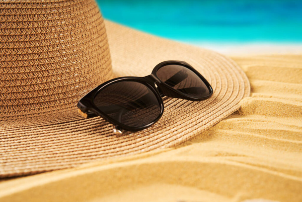 Summer time vacation concept. Straw hat, seashells on the sand beach and sea background. Travel - Valokuva, kuva