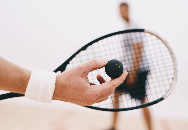 Hora de servir algunas habilidades serias de squash. un hombre sirviendo una pelota con una raqueta durante un juego de squash - Foto, imagen