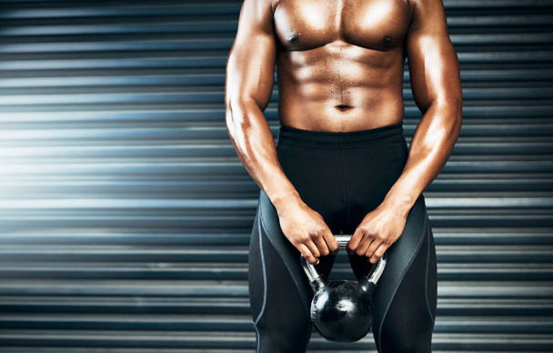 Break yourself to remake yourself. Closeup shot of a muscular man lifting weights against a grey background - Photo, Image
