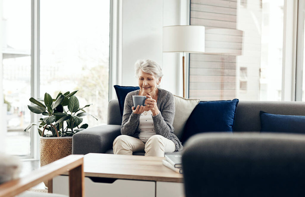 Im not grumpy, not after coffee. a senior woman enjoying a cup of coffee while relaxing at home - Valokuva, kuva