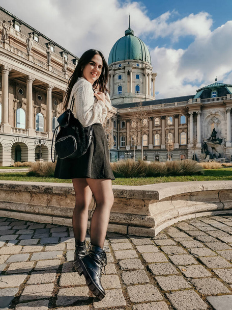 A vertical of an attractive young woman standing in the courtyard of Buda royal palace in Budapest - Valokuva, kuva