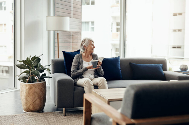 Os anos cinzentos são tão bons para mim. uma mulher idosa desfrutando de uma xícara de café enquanto relaxa em casa - Foto, Imagem
