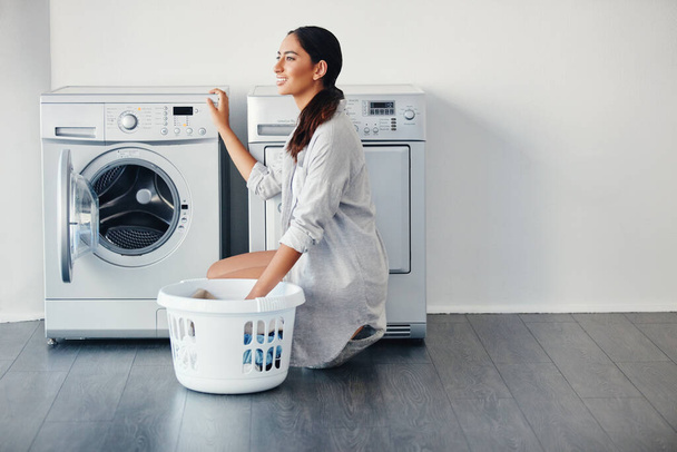 Das Wetter ist zum Waschen genau richtig. eine junge attraktive Frau wäscht ihre Wäsche zu Hause - Foto, Bild