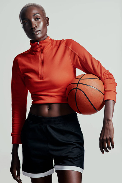 Basketball tut dem Körper gut. Studioaufnahme einer attraktiven jungen Frau beim Basketballspielen vor grauem Hintergrund - Foto, Bild
