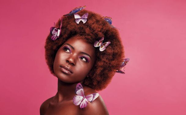 Goodness that hair. Studio shot of a beautiful young woman posing topless with butterflies in her hair against a purple background - Φωτογραφία, εικόνα