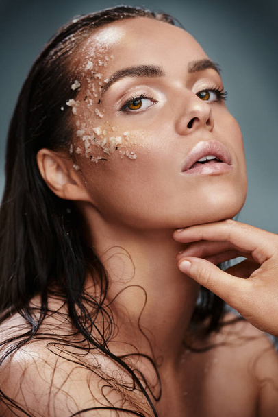 Exfolia y mantén tu piel perfecta. una hermosa joven posando con sal en la cara - Foto, Imagen
