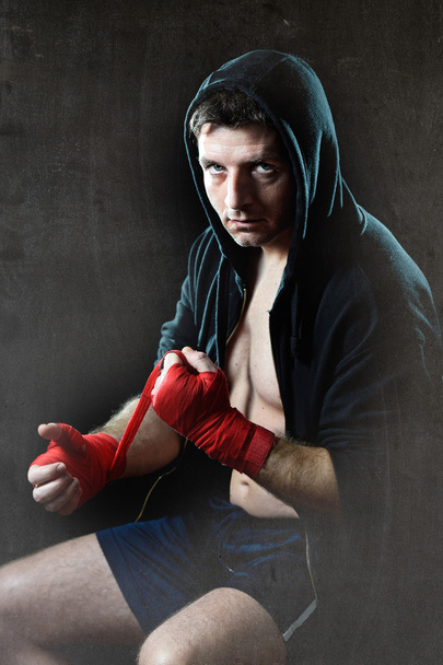 Muž v boxu hoodie mikiny s kapucí na hlavě obtékání ruce zápěstí před tělocvik - Fotografie, Obrázek