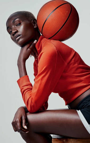 Hogy kezeled a labdát? Stúdió lövés egy vonzó fiatal nő kosárlabdázik a szürke háttér - Fotó, kép