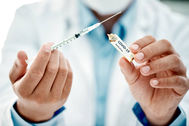Weve got a world to save. a scientist extracting medication using a syringe from an ampoule with 2019-nCov on it - Foto, Bild