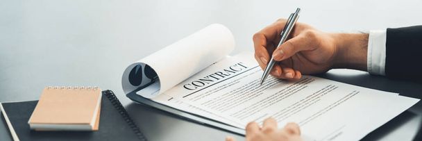 Businessman signs contract agreement paper or business legal form with trust and professionalism. Closeup of hand holding pen in corporate meeting for official business deal. Equilibrium - Photo, Image