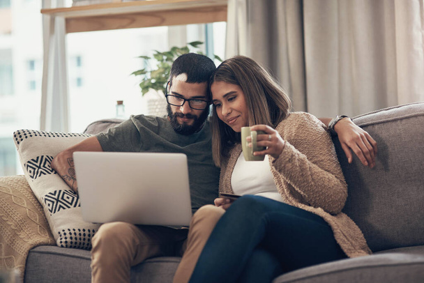 You can find so much more at the online store. a young couple using a laptop and credit card on the sofa at home - Photo, Image