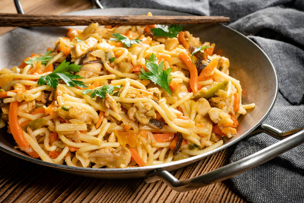 Fried noodles with chicken and vegetables. Chicken chow mein. - Foto, afbeelding